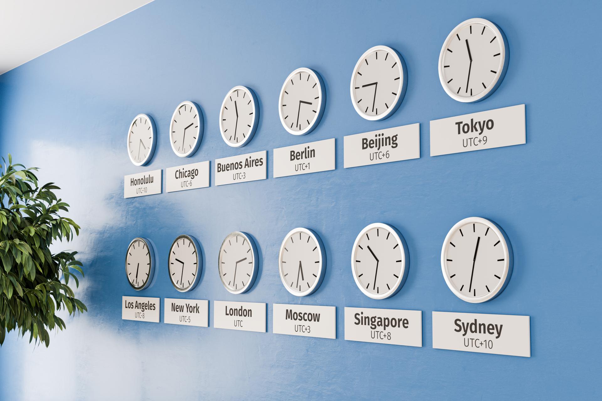 Developer looking frustrated at clock showing different time zones around the world